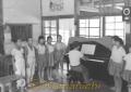 ピアノを囲んで校歌を歌う吉尾小学校の児童＝芦北郡芦北町