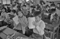 二学期終了　通知表を見る児童＝熊本市の碩台小学校