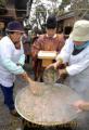 浮島神社で七草がゆ祭り　おはらいをした七草がゆを鍋に戻す宮司ら＝上益城郡