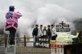 立ち入り規制が解除された中岳第一火口縁で記念撮影する観光客ら＝阿蘇山上