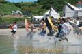 富岡海水浴場の海開きで海に入る苓洋高の生徒たち＝苓北町