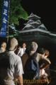 「納涼　夜の熊本城めぐり」でライトアップされた熊本城に見入る家族連れ＝熊本市
