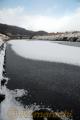氷が張り川面に雪が積もった中原川＝南小国町