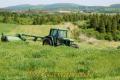 １番草の刈り取りをする大型トラクター＝阿蘇市