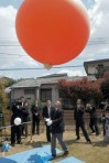 遺骨が入ったバルーンを飛ばす山崎さん＝熊本市